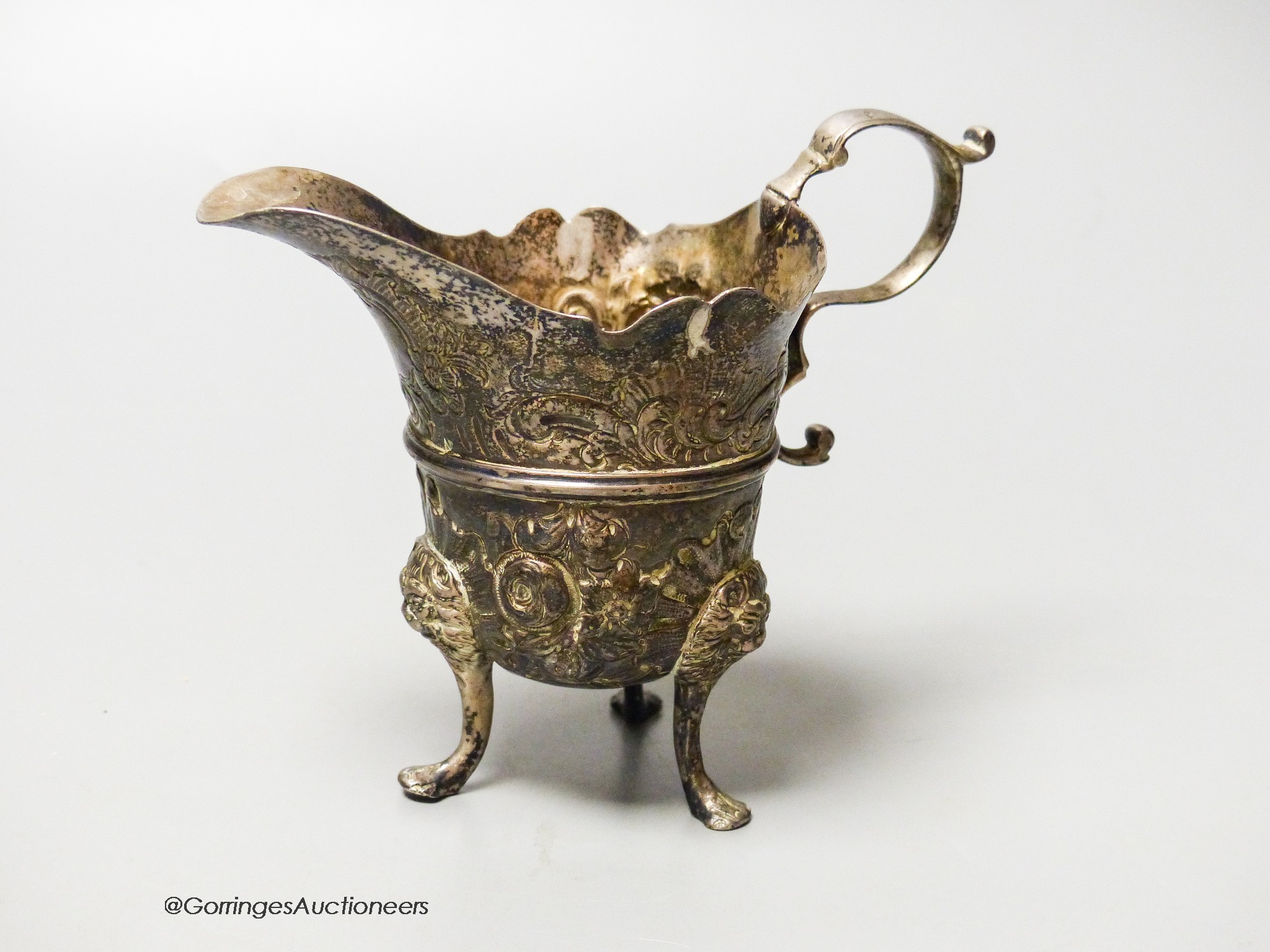 An 18th century Irish? silver cream jug, with later embossed decoration, marks rubbed, height 11.1cm, 4.5oz.